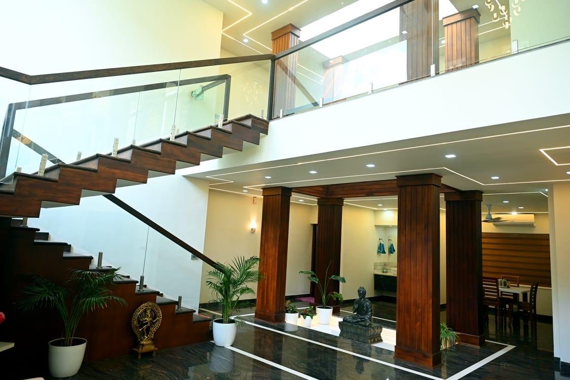 Elegant Prakrithi interior with wooden columns and open staircase